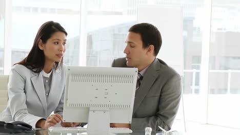 Two-disappointed-colleagues-working-at-computer