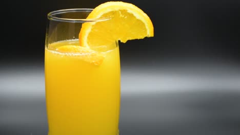 orange soda drink in a glass, dropping slices of orange in