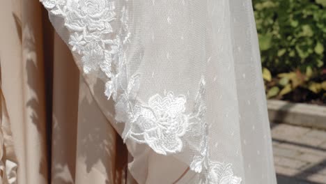 gorgeous details of a white and skin colored designer wedding dress outside in the garden