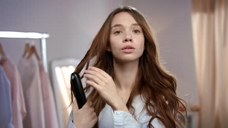 Hermosa-Mujer-Peinando-El-Cabello-Con-Plancha.-Chica-Morena-Planchando-El-Cabello-Por-La-Mañana