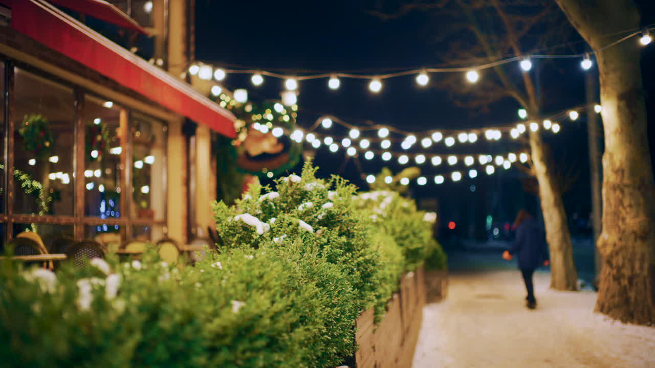 Decorative string lights illuminating a pedestrian walkway at night