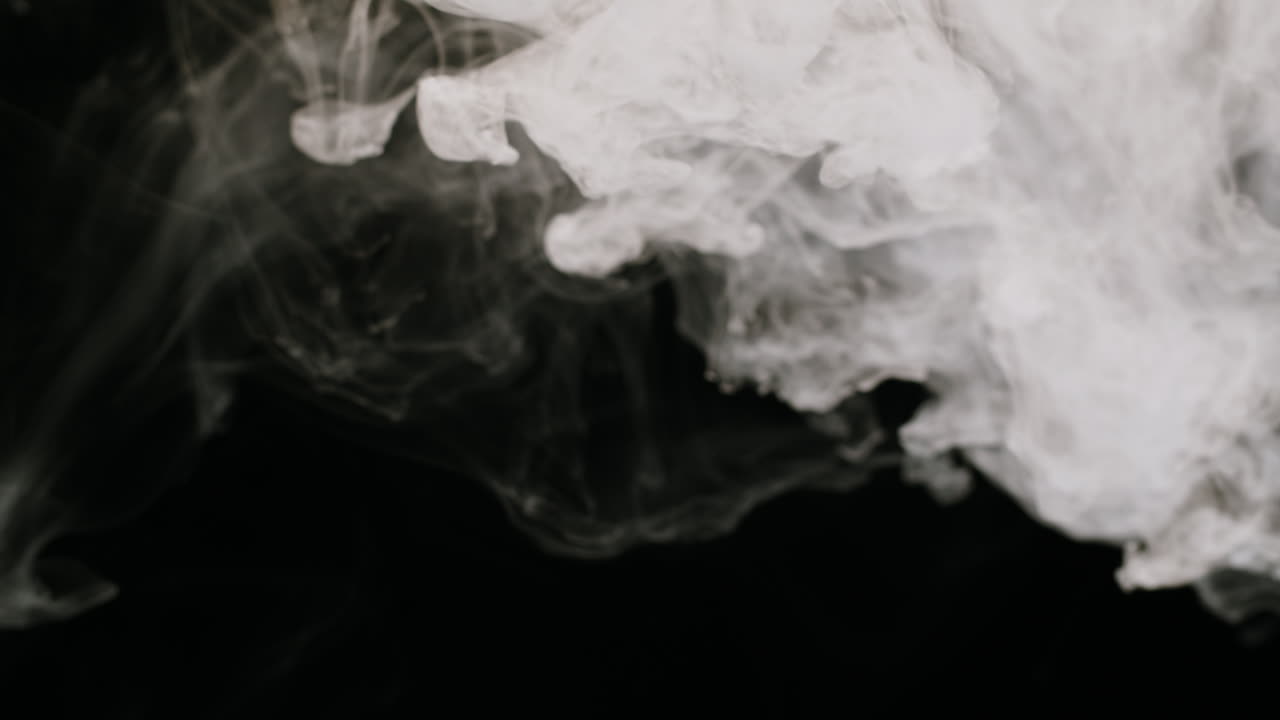Dense White Smoke Swirling and Dissipating on Black Background