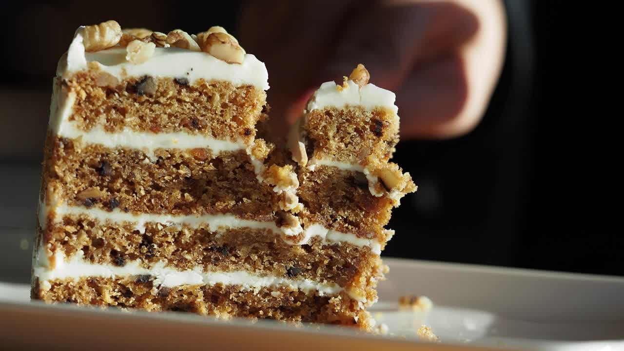 A piece of carrot cake being eaten