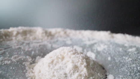 coconut shavings bounce on moving surface against grey wall