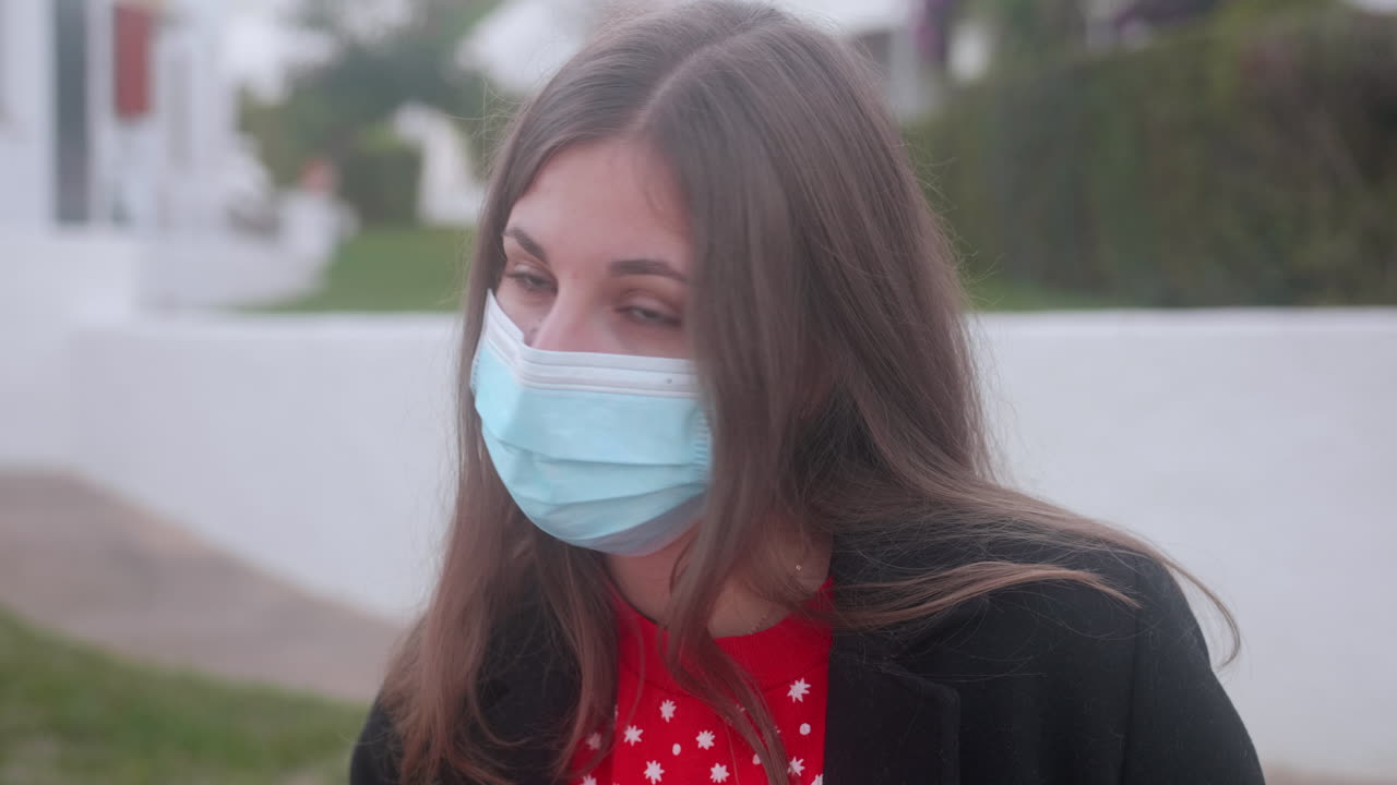 Ragazza che indossa una mascherina chirurgica mentre guarda la telecamera