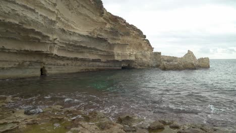 mar mediterráneo tranquilo cerca de la pared de piedra caliza de la playa de il-kalanka en malta