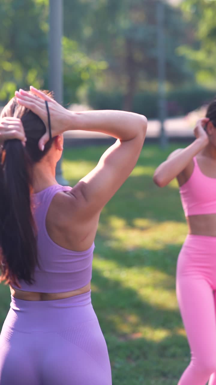 mujer atando su cabello en una cola de caballo mientras hace ejercicio al aire libre