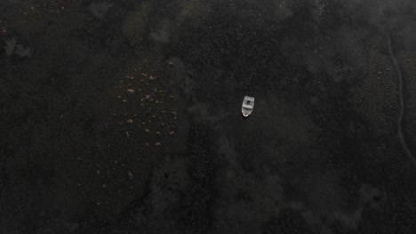 White-row-boat-on-Sanur-beach-at-Bali-Indonesia-during-sunrise,-aerial