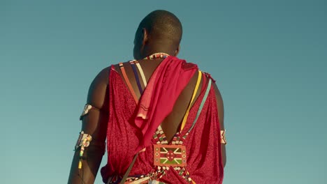 rear of a young male masai warrior wearing traditional clothing in a tribe in kenya