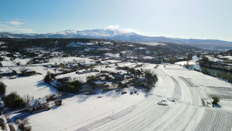 aerial panoramic view of a rural landscape with fields and houses coved with snow on a beautiful sunny winter day, dalmatia, croatia