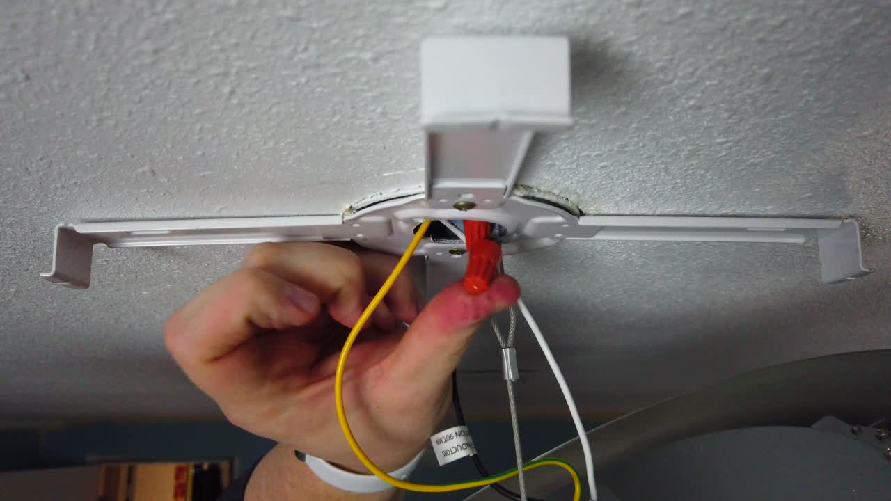 Stuffing up the wire nuts connected to the new light into the light electrical box