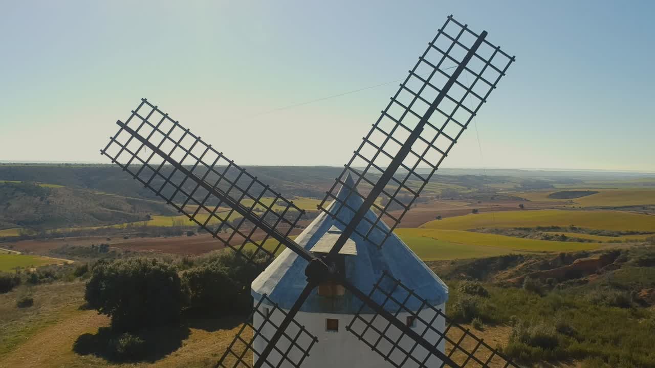 toma aérea hacia atrás volando entre las aspas de los molinos de viento en españa.