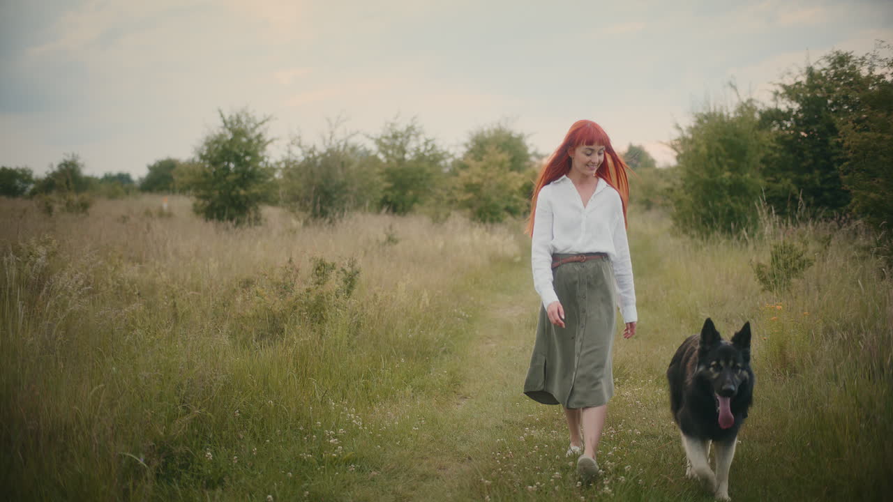 Woman walking with her dog in a field