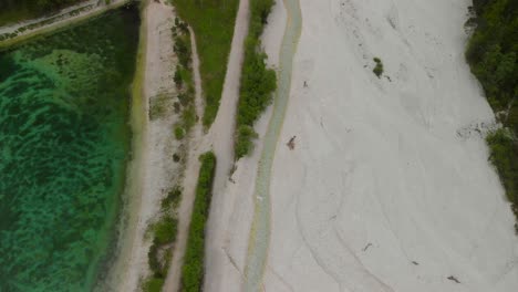 Aerial-shot-of-a-turquoise-coloured-lake-in-the-mountains-of-Slovenia