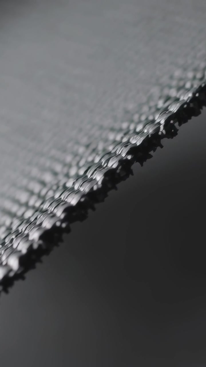 Vertical video: Shifting camera focusing, revealing macro knitted edge in studio for stitch detail