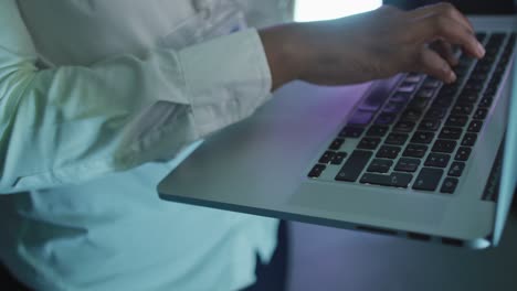 african american male computer technician using laptop working in business server room