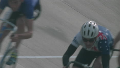 a group of cyclists ride around a track