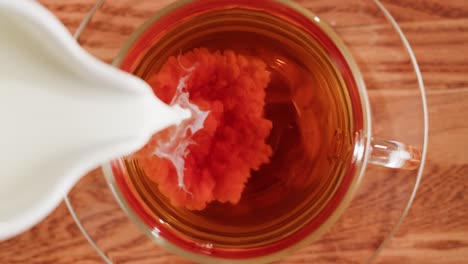 pouring milk into tea from an overhead perspective