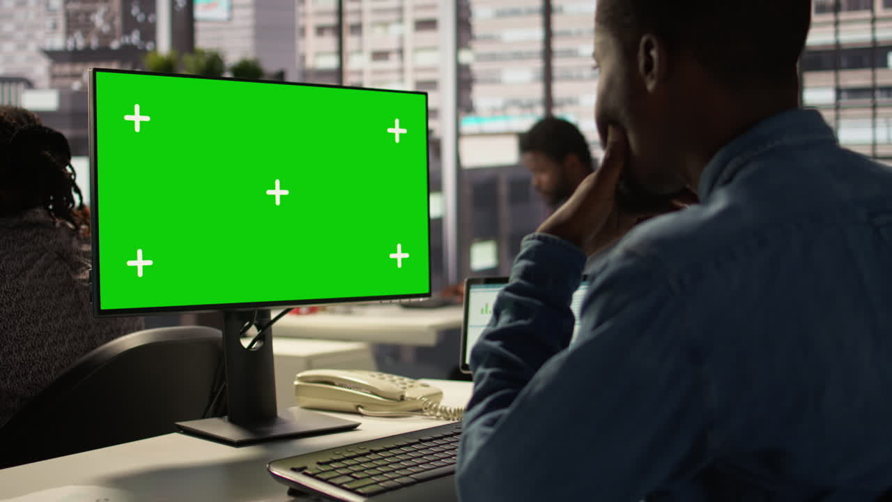 impiegato che usa un computer con uno schermo verde