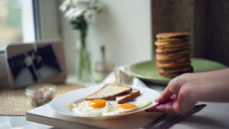 Fried-eggs-and-slices-of-toast-bread-on-white-plate