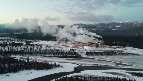 pulp mill in action: aerial view of industrial facility in cranbrook, british columbia processing raw materials for paper production on a winter morning