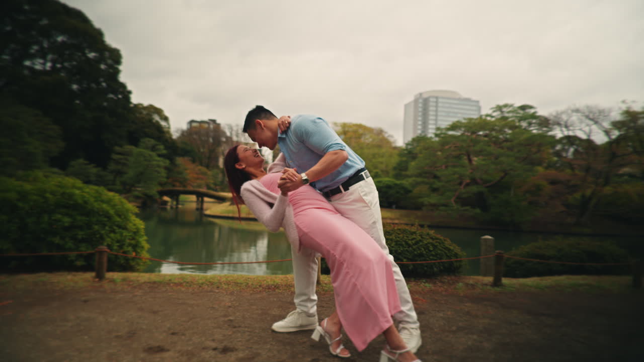 una pareja bailando en un parque.