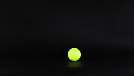 a tennis ball moves across a dark background