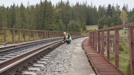 railroad worker inspecting tracks on a bridge