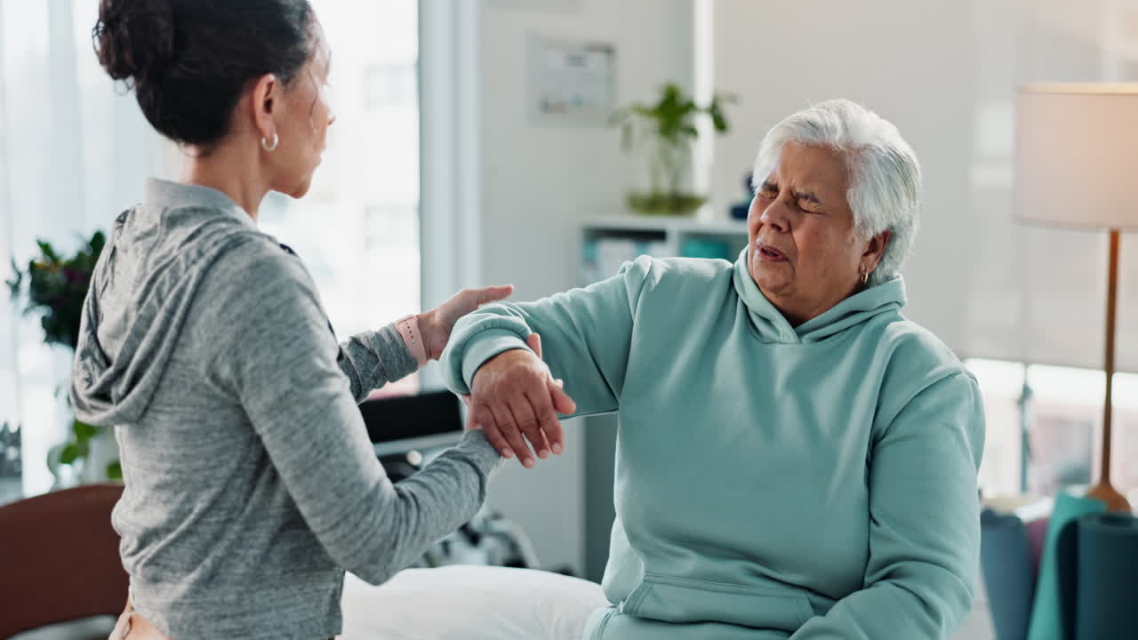 un profesional de la salud ayuda a una anciana con fisioterapia