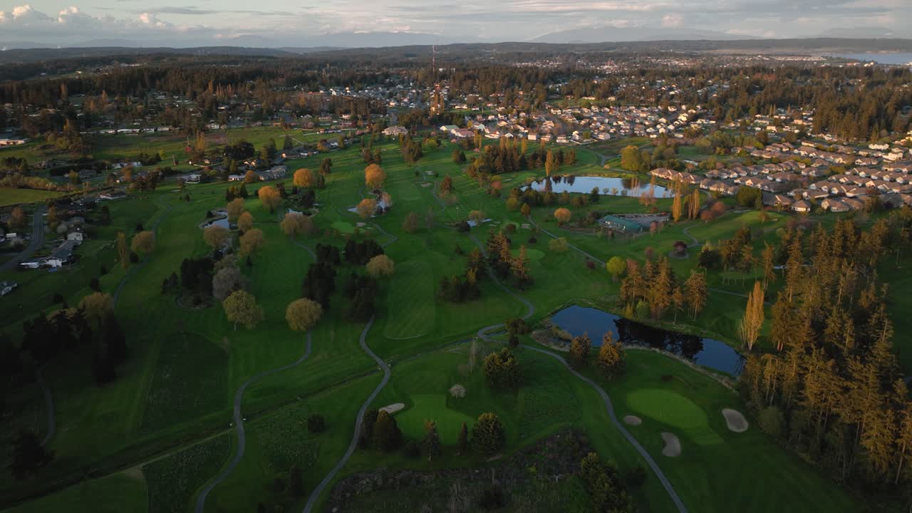 High up aerial showing Whidbey Island's golf course in Oak Harbor surrounded by neighborhood communities.