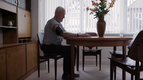 senior man checking blood pressure at home