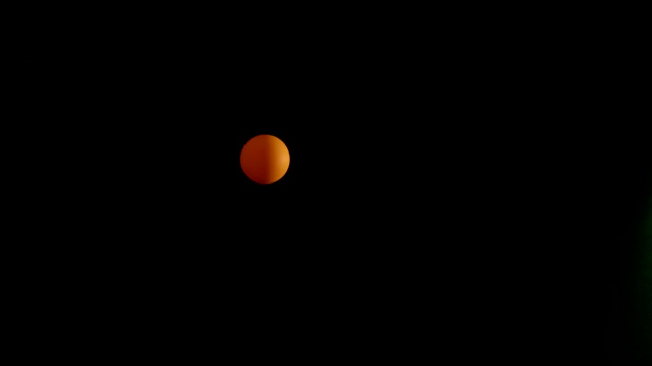 Orange ball bouncing in a dark environment