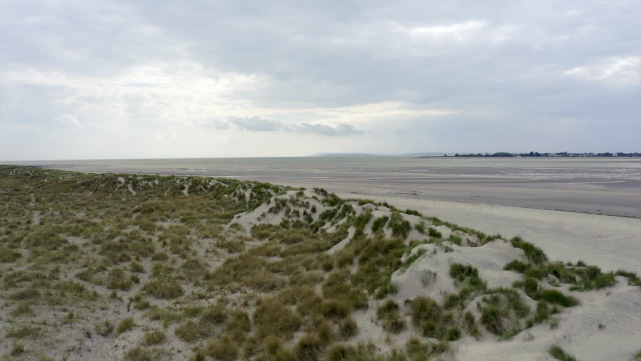 4K Drone flying at beach above sand dunes.