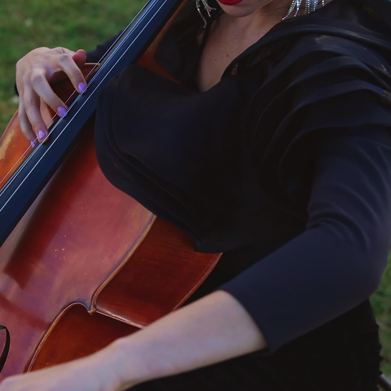 Perfomance of musician plays the cello. Young pretty violinist playing on nature