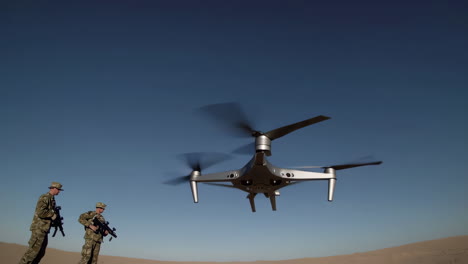 military personnel and drone in desert