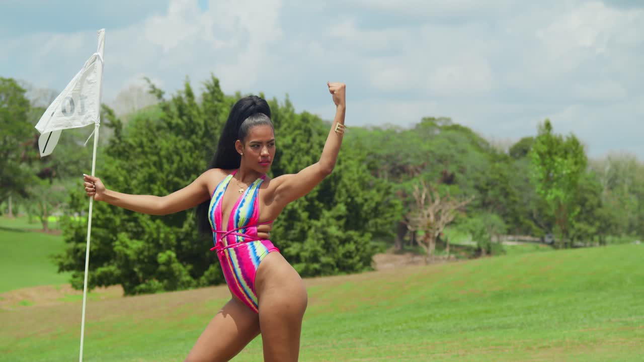 비키니를 입은 젊은 여성이 열대 카리브 해의 트리니다드 섬의 골프 코스에서 열린 광활함을 감상하고 있습니다.