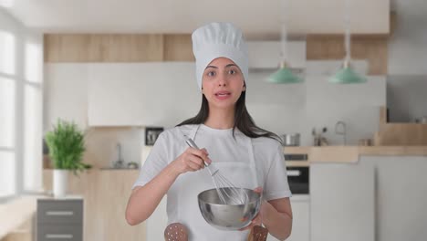 una chef profesional india haciendo comida mientras explica