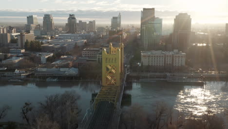 Luftdrohne-Nach-Oben-Kippen-Und-Bei-Sonnenaufgang-An-Der-Tower-Bridge-Und-Der-Innenstadt-Von-Sacramento,-Ca,-Einschließlich-Old-Sacramento---State-Capitol-Im-Hintergrund-Vorbeischieben