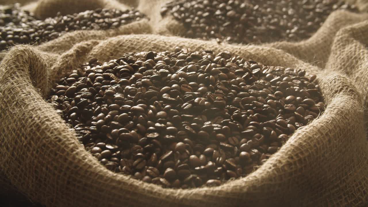 Fresh roasted coffee beans falling into linen sack in slow motion