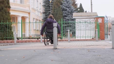 a person with a disability moves along the street in a wheelchair