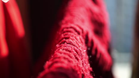 close up of a red cloth being held by a white clothes peg