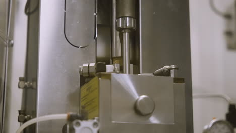 close up of an automatic corking device in wine bottling machinery