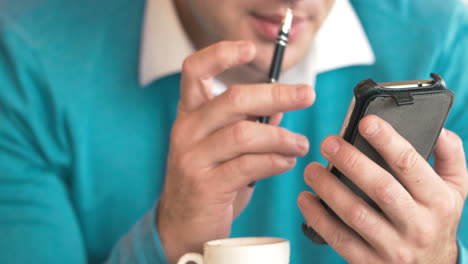 hombre usando teléfono celular y tomando notas