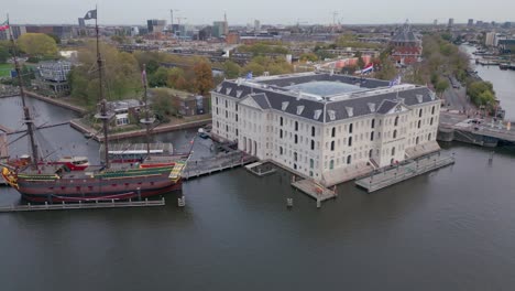 large ship on the water next to museum in amsterdam