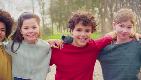 retrato de niños divirtiéndose jugando al aire libre con los brazos entre sí