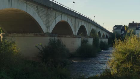 Under-a-large-bridge-of-arches-river-water-current-flowing-downwards