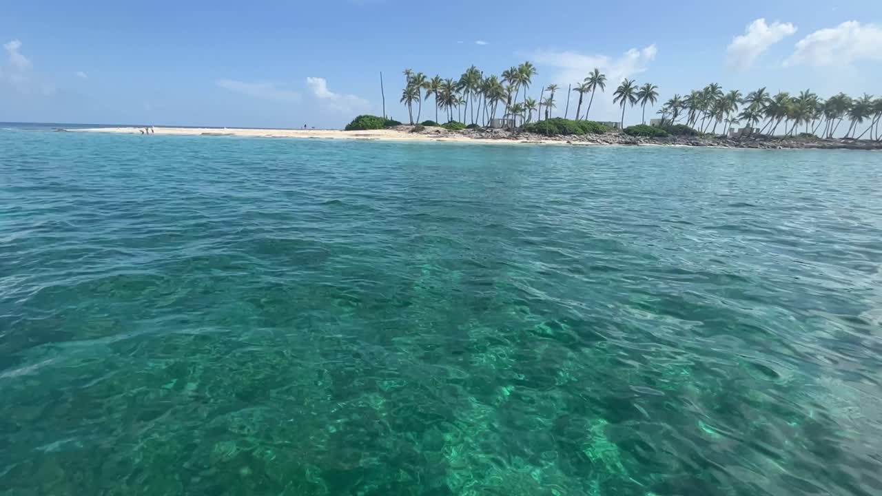 Вид с моря на небольшой остров с пальмами