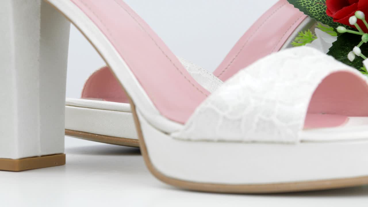 화이트 배경 클로즈업에 은 장미와 함께 우아한 럭셔리 라스 신부 결혼 신발과 꽃줄