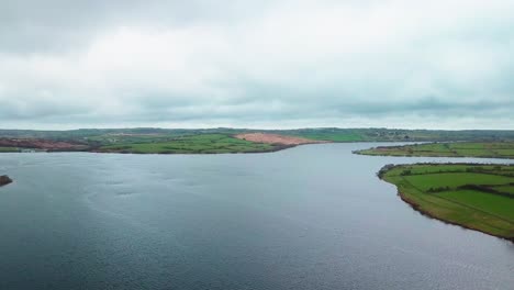 Beautiful-calm-Stithians-Lake-under-a-cloudy-sky-in-the-UK---aerial