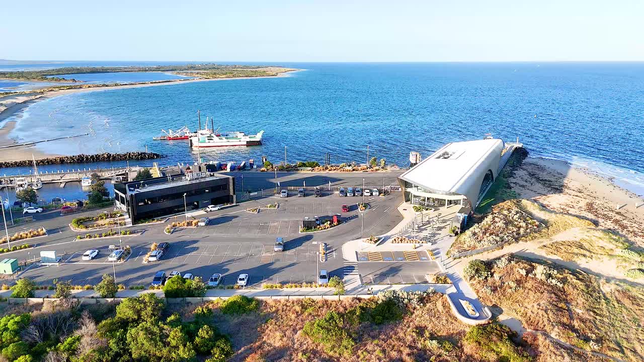 Aerial footage shows a harbor with boats and cars in Bellarine, Victoria, under bright daylight